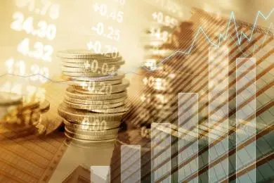 Stacks of gold coins overlaid with market price charts and figures